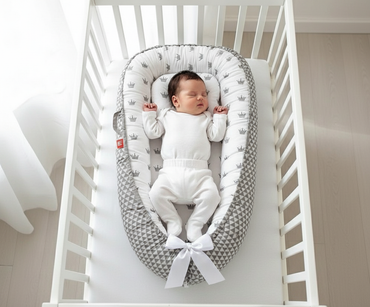 Bébé dans réducteur de lit avec couronnes